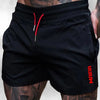Black men's stretch performance drawstring shorts worn by a model with visible tattoos.