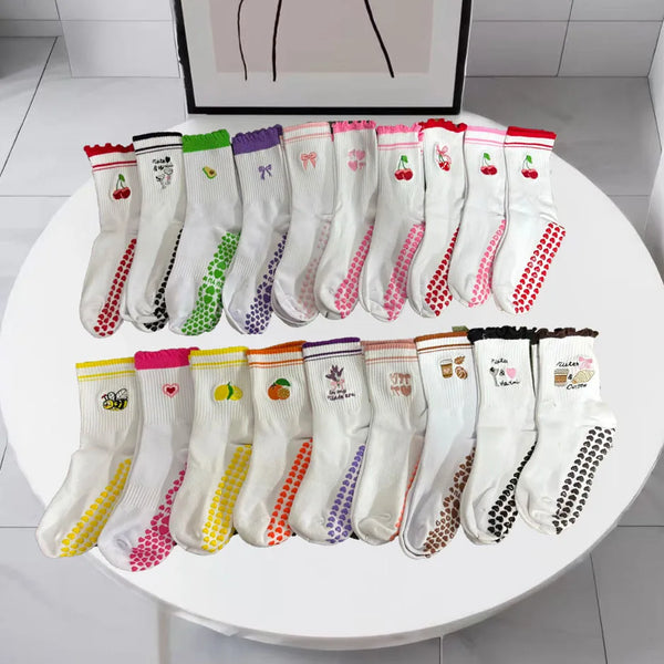 Collection de chaussettes de yoga et de fitness en tricot pour femmes, de différentes couleurs et motifs, présentées sur une 