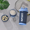 A dark blue sports shaker bottle with a handle is shown next to a mesh tennis racket and a bowl of white powder.