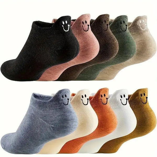 An assortment of eight low-cut ankle socks in various muted colors with smiling embroidery