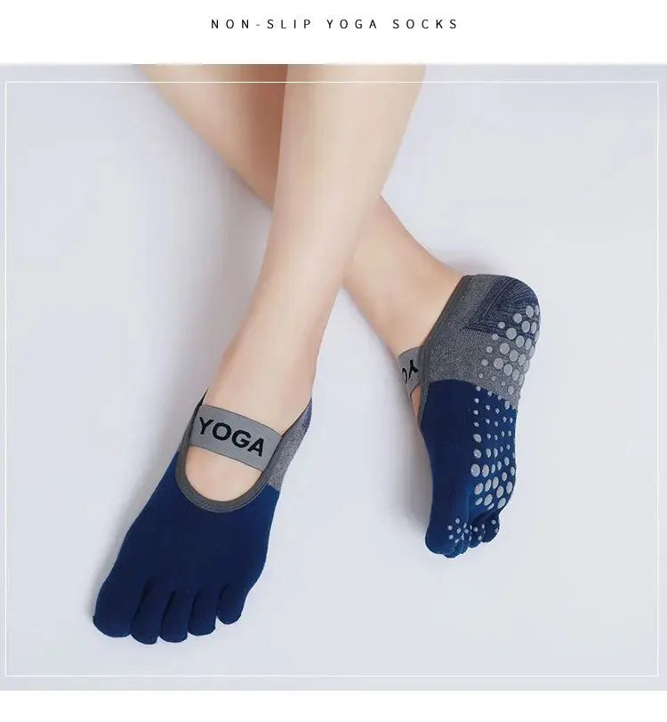 A close-up of a person's foot wearing dark blue silicone yoga socks with gray accents.