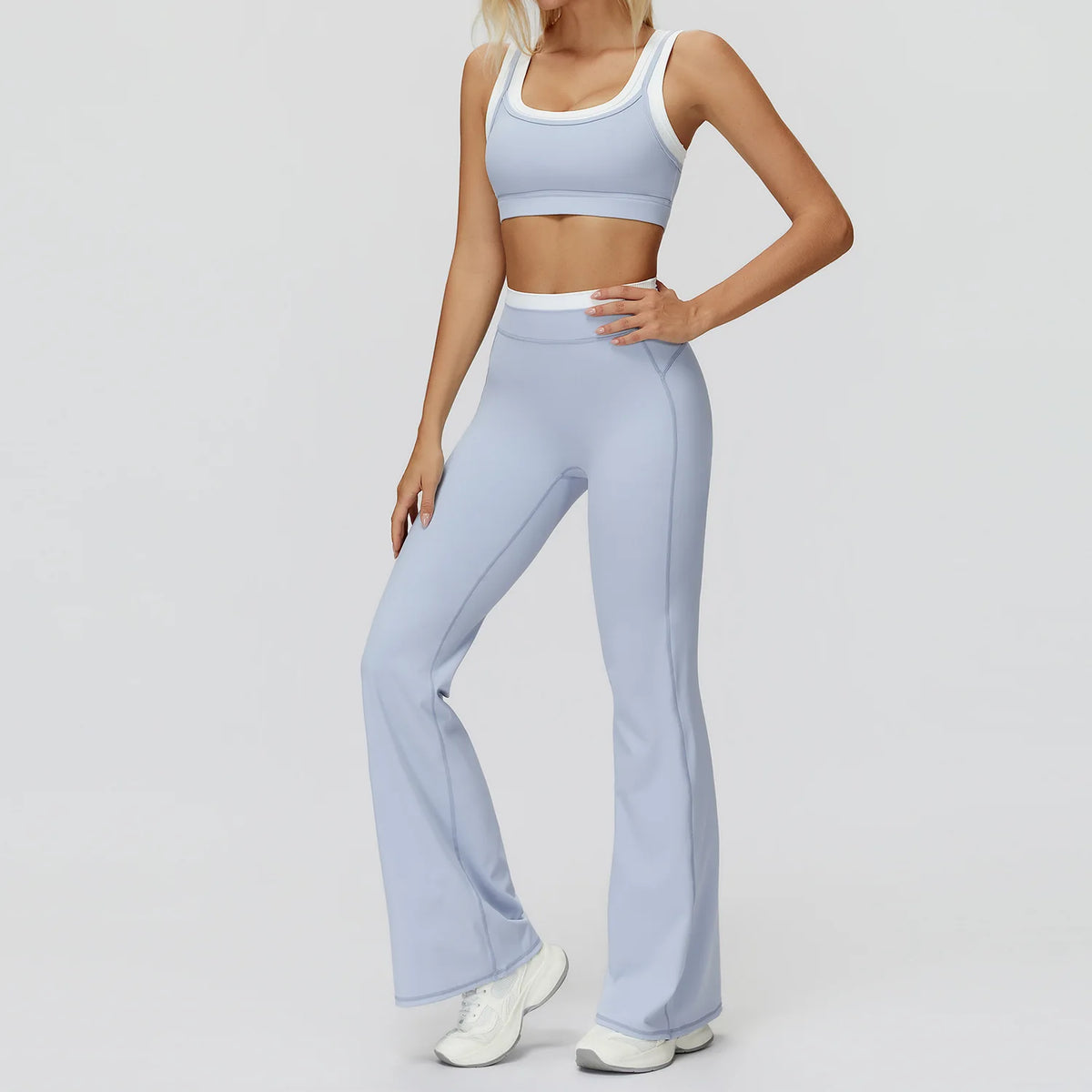 Eine Frau trägt ein hellblaues Yoga- und Sport-Trainingsanzug-Set mit cropped Top und passenden Hosen.