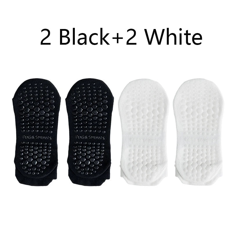 Four pairs of non-slip yoga socks, two black and two white.