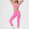 Eine Frau modelliert leuchtpinke, nahtlose Yoga-Leggings und ein passendes Sport-BH-Oberteil.