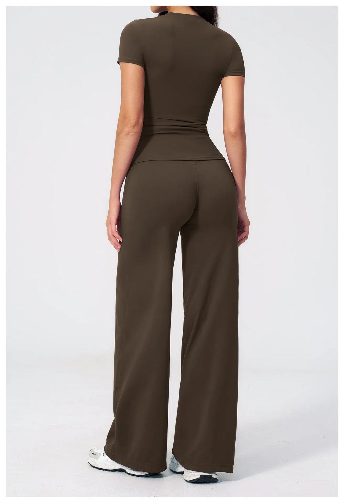 A woman wearing a dark olive green high-waist yoga and gym leggings set.