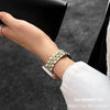 A hand wearing a stainless steel watch band for a Huawei fitness tracker on a wrist.