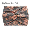 A gray fabric headband featuring a floral pattern in peach and pink tones, tied in a cross knot.