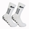 Une paire de chaussettes de football blanches antidérapantes, montrées sur un fond blanc.