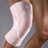 A pink compression knee support sleeve worn on a person's leg.