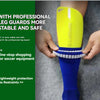 A hand is holding a bright yellow soccer leg guard on a person's lower leg.