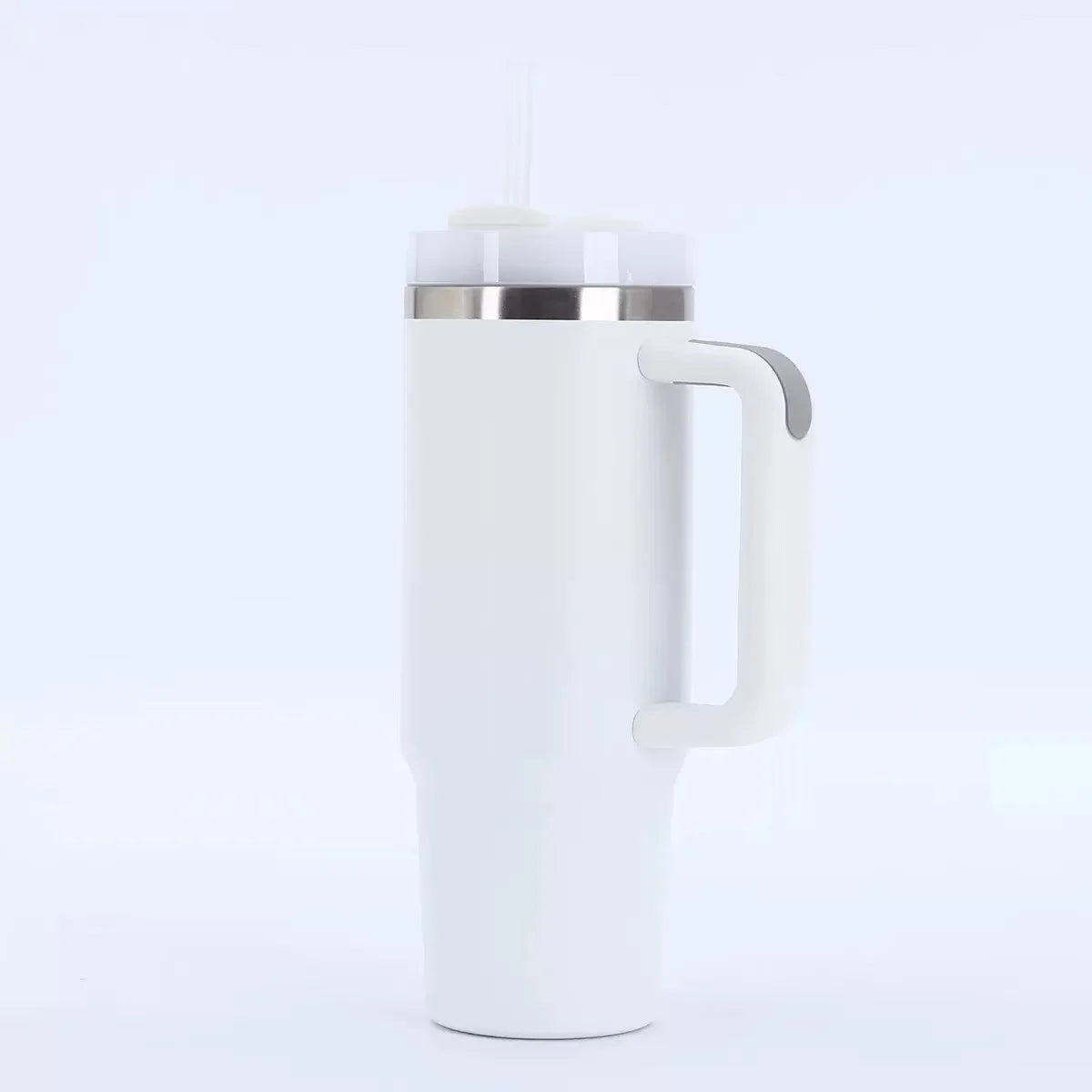 Tasse isotherme en acier inoxydable blanc avec couvercle et paille argentée, sur fond blanc.