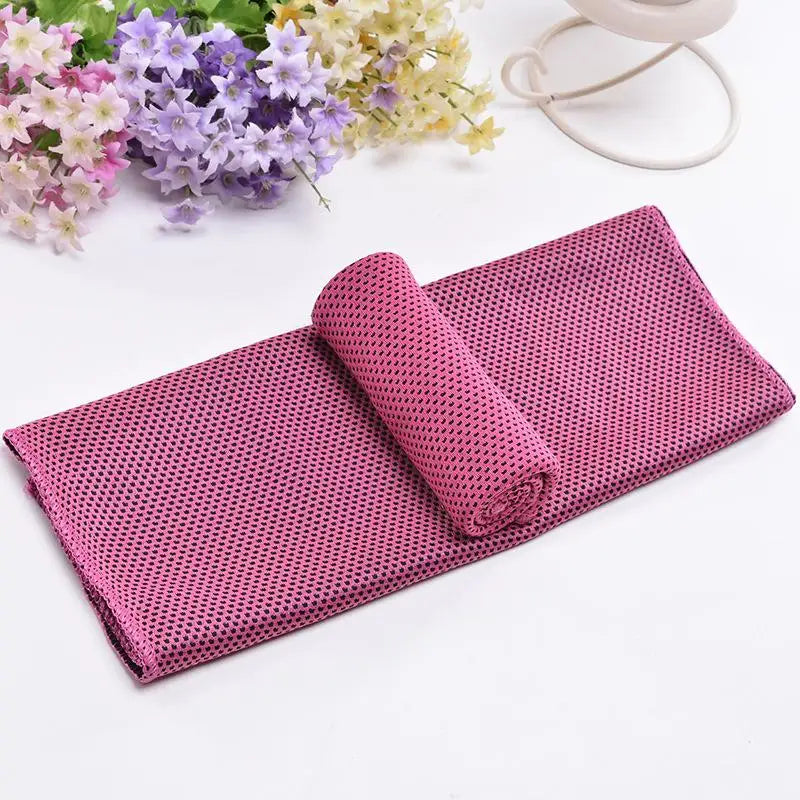 Serviette de refroidissement rose en filet roulée à côté d'un bouquet de fleurs violettes et jaunes.