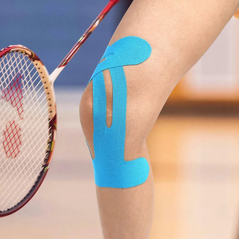 Blue kinesiology therapy tape applied to a person's knee for support.