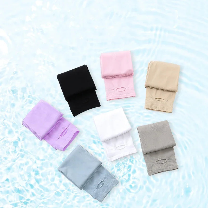 A collection of folded UV protection arm sleeves in various colors including black, pink, beige, and gray on a light blue sur