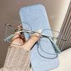 A hand is holding a pair of stylish anti-blue light reading glasses with a light blue frame and a beige strap against a light
