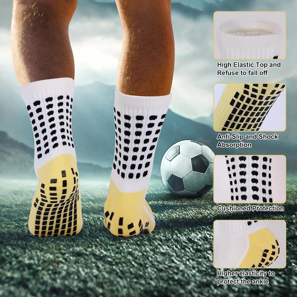 Ein Paar gelber Grip-Socken mit schwarz gepunktiertem Muster auf einem Fußballfeld, das Elastizität hervorhebt
