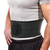Person wearing a black abdominal hernia support brace over a gray shirt and dark pants.