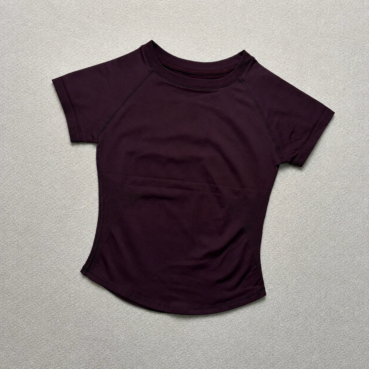 A dark purple seamless high-waist yoga top for women shown against a light background.