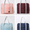 Three versions of a foldable travel duffel bag in pink, maroon, and blue fabric.