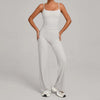 A woman models a light gray high-waist yoga and fitness tracksuit set consisting of a cropped top and matching full-length pa