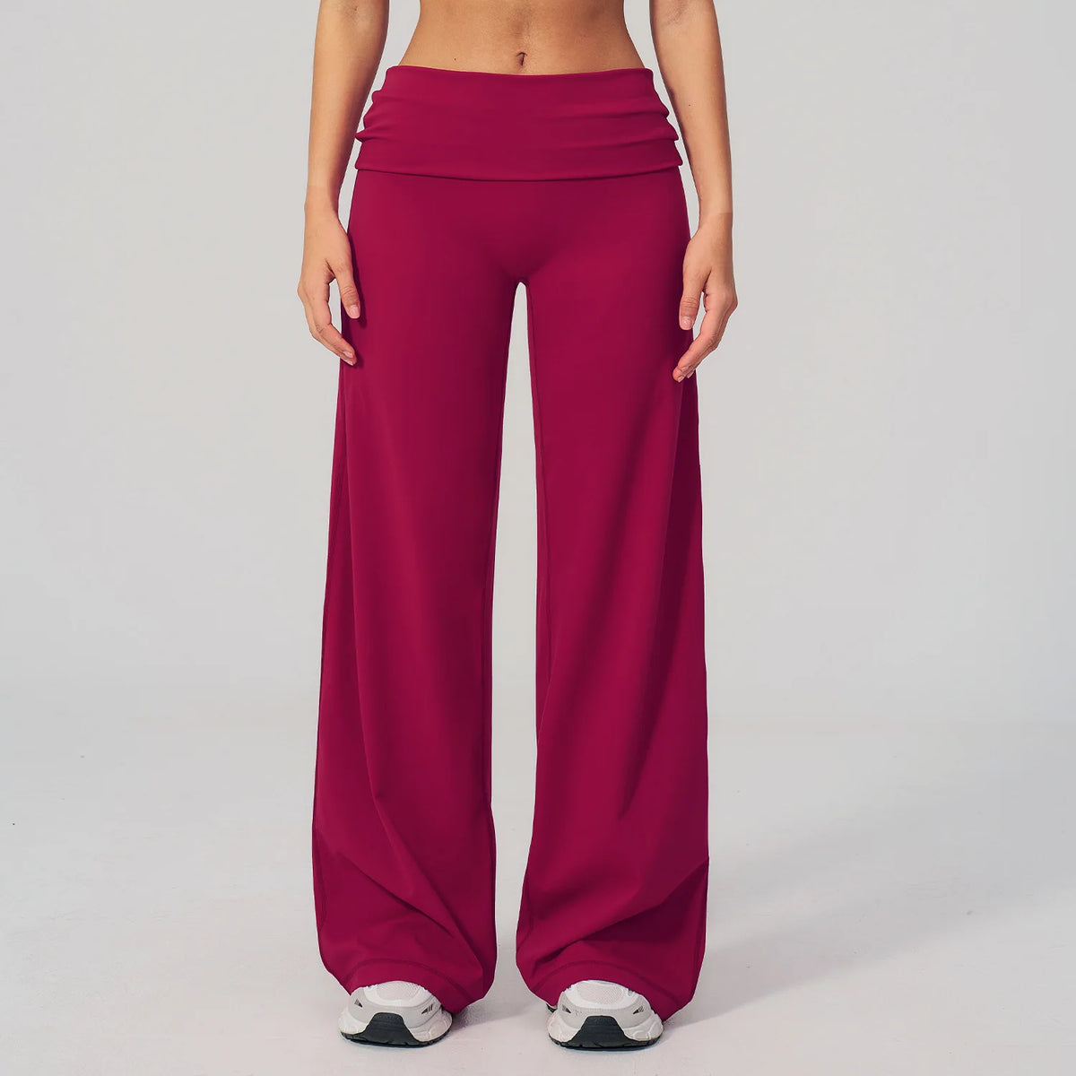 A model is wearing a solid magenta flared high-waist yoga and fitness pant.