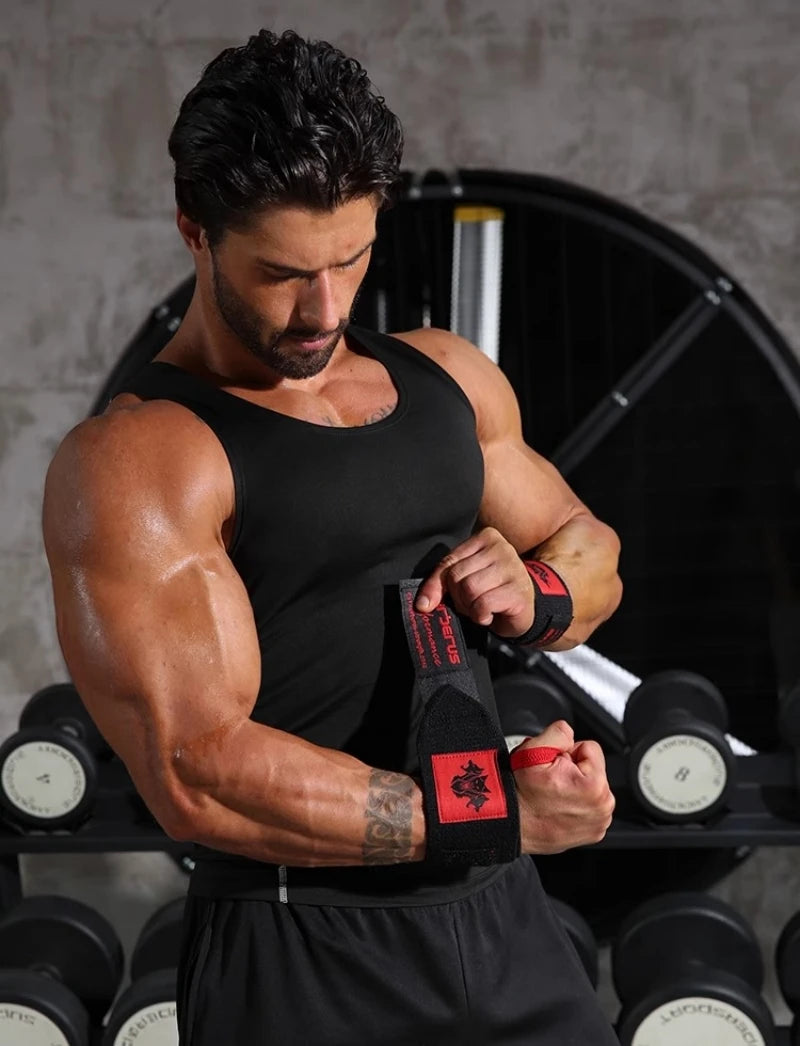 Un homme musclé portant un débardeur noir et des poignards soulève des poids dans une salle de sport.
