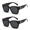 Black oversized sunglasses with gold accents shown in a studio shot.