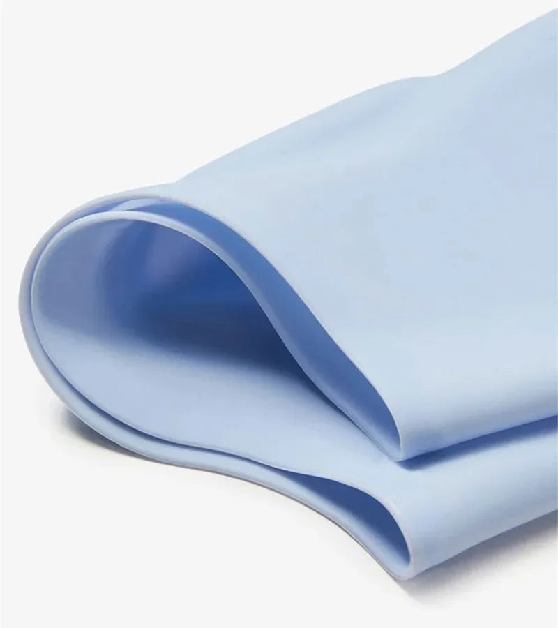 Light blue waterproof silicone swim cap folded and displayed on a white background.