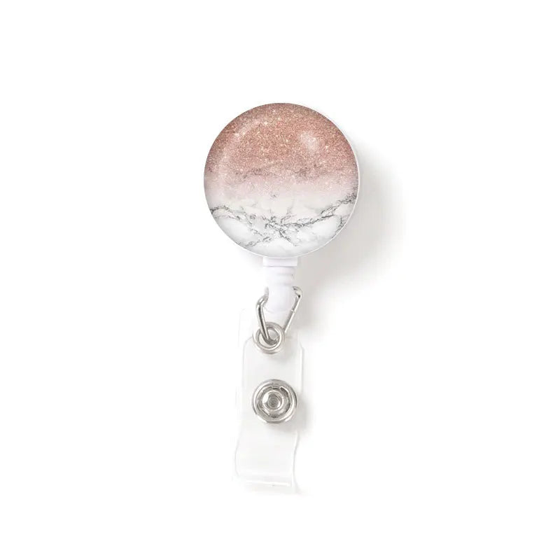 A round, translucent badge reel with a speckled finish attached to a clear plastic keychain.
