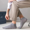 Nahaufnahme eines Mannes in hellbeigen Hosen und grauen Knöchelsocken.