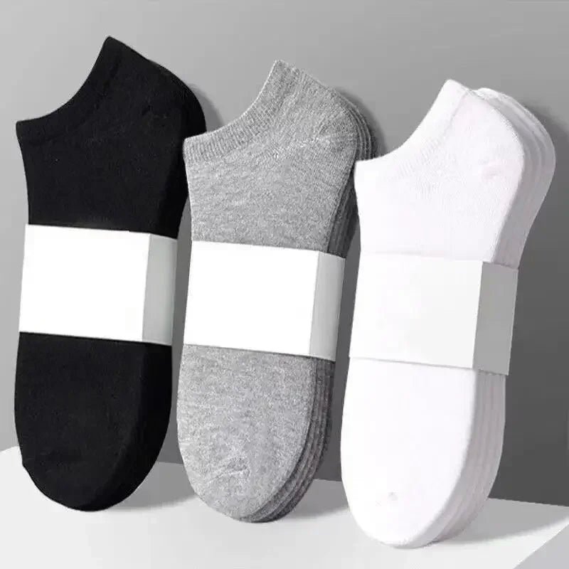 Tres pares de calcetines de algodón transpirables para el tobillo en negro, gris y blanco mostrados uno al lado del otro.