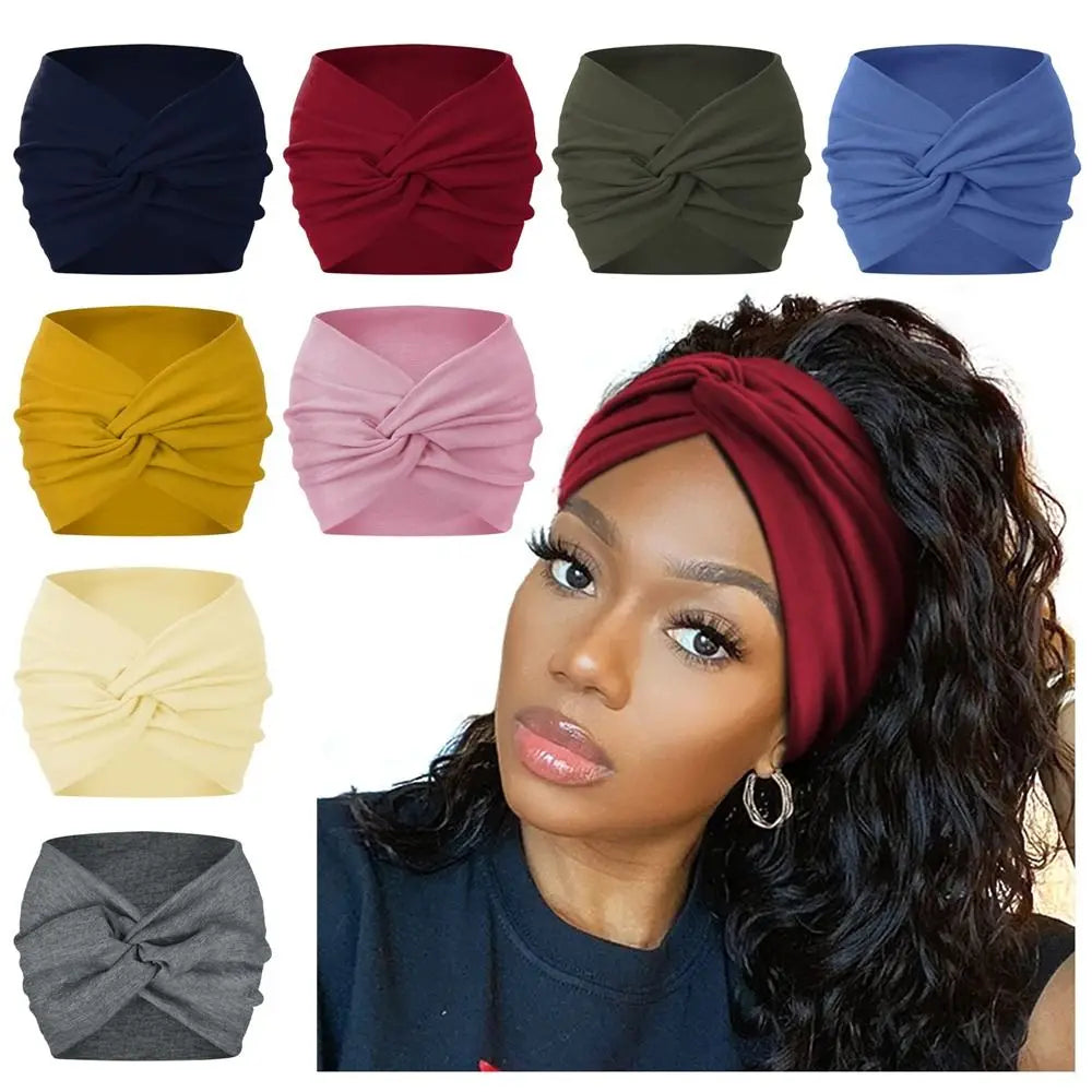 A collection of cross-knotted fabric headbands in various colors including navy, red, olive green, blue, yellow, and pink, di