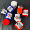 A collection of various colored boxing hand wraps rolled up on a dark surface.