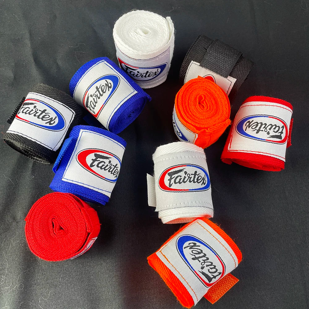 A collection of various colored boxing hand wraps rolled up on a dark surface.