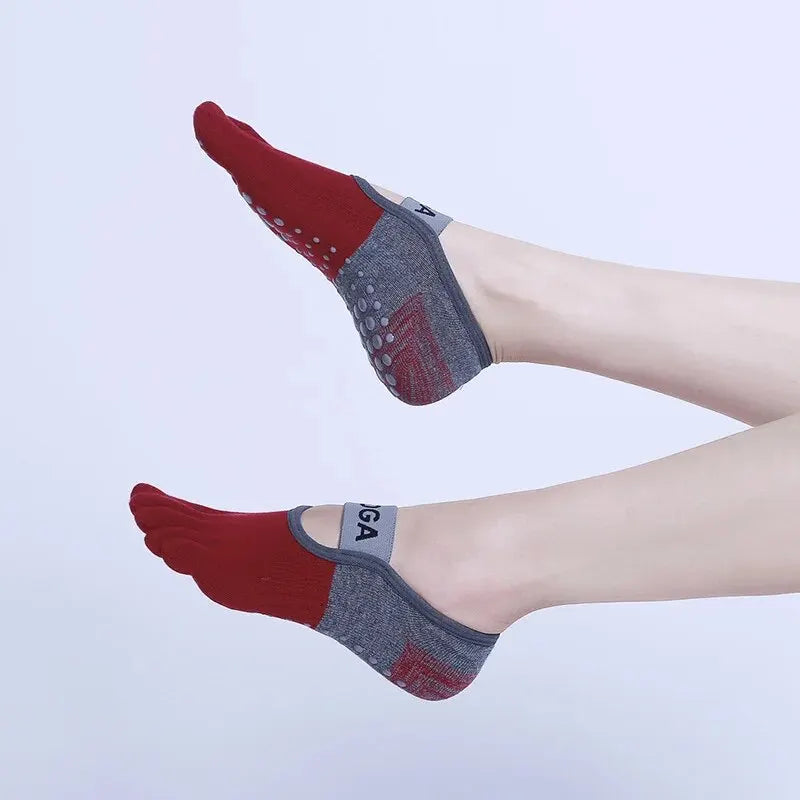 A pair of red and gray breathable silicone yoga and fitness socks worn on a foot.