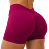 A woman wearing seamless magenta yoga shorts during a workout.