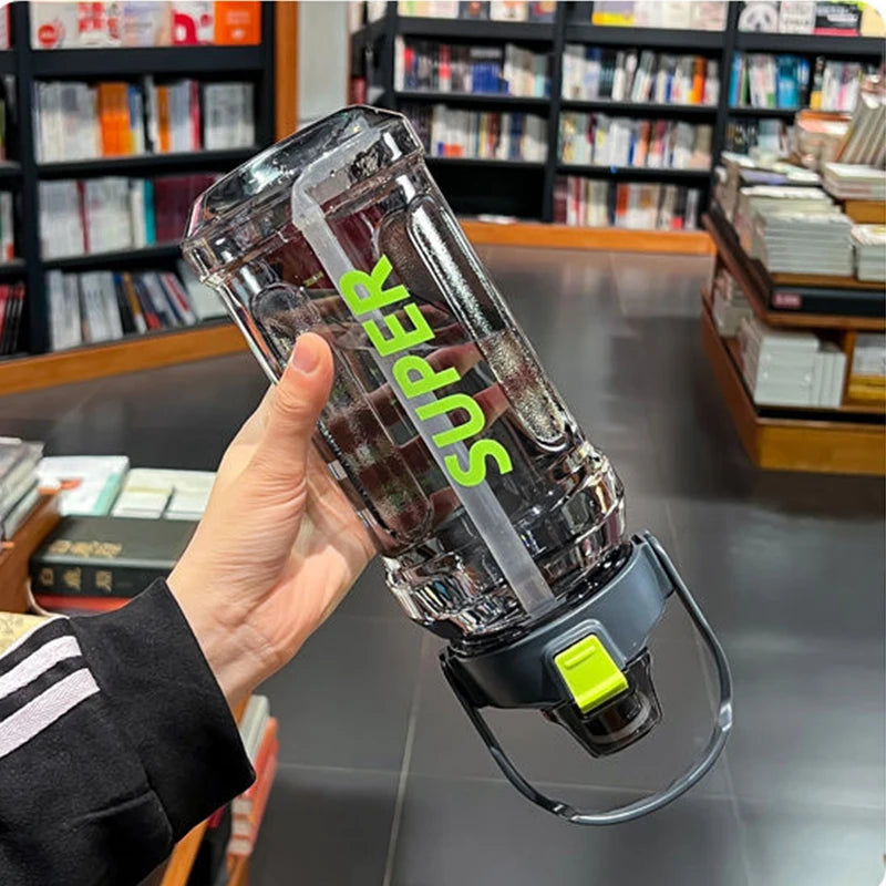 A hand holds a clear insulated sports water bottle with a leakproof straw, featuring green lettering.