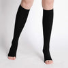 Black medical grade knee high compression stockings worn on a person's legs.