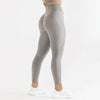 Un modèle portant des leggings de yoga sans couture à taille haute gris et un haut clair.