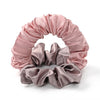 A headband made of satin fabric in shades of pink and mauve, rolled into a decorative wreath shape.