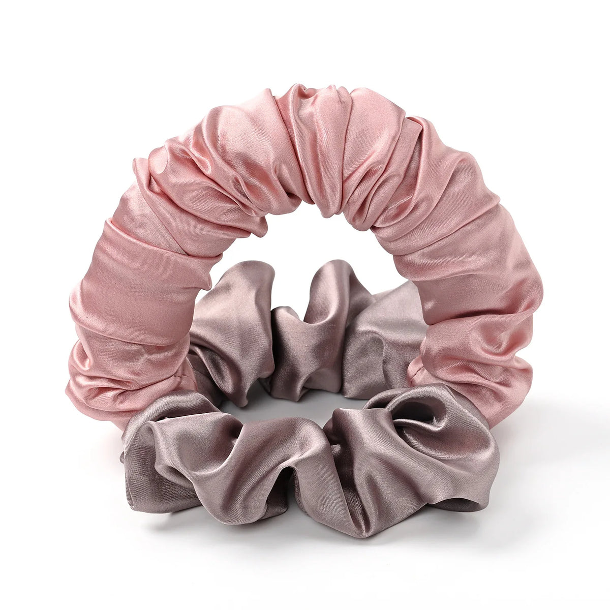 A headband made of satin fabric in shades of pink and mauve, rolled into a decorative wreath shape.