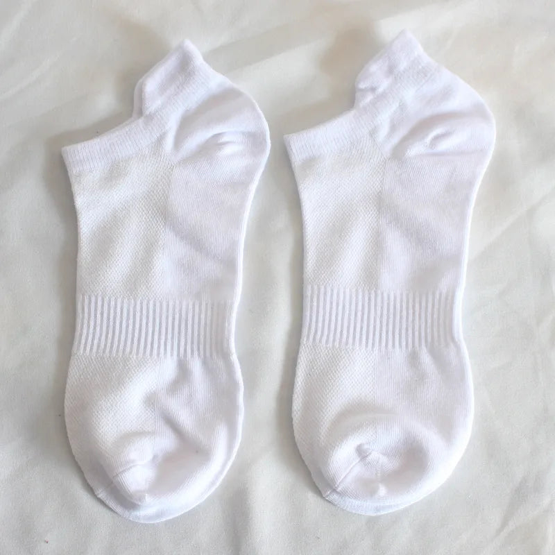 Ein Paar weiße Socken liegen flach auf einer weißen Oberfläche.
