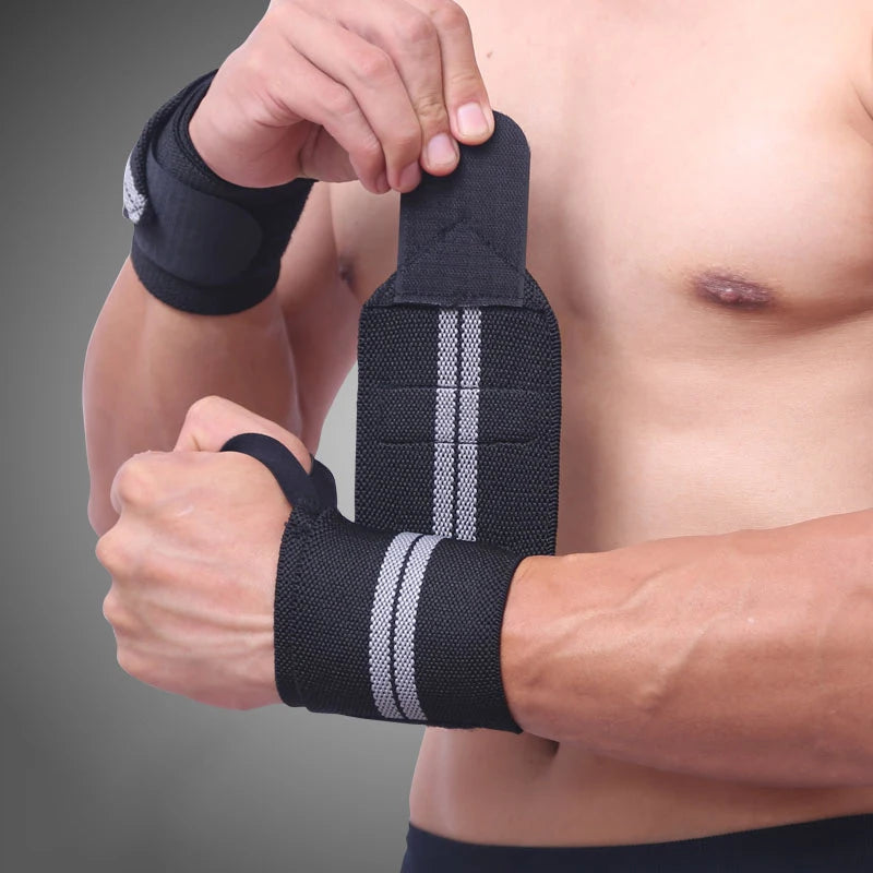 A person is applying black heavy duty wrist wraps to their forearm for strength training.