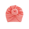 Solid coral pink cotton baby turban headwrap with ruched top and a round knot.
