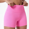 Gros plan d'une femme portant des shorts de yoga et de sport roses vifs à taille haute.