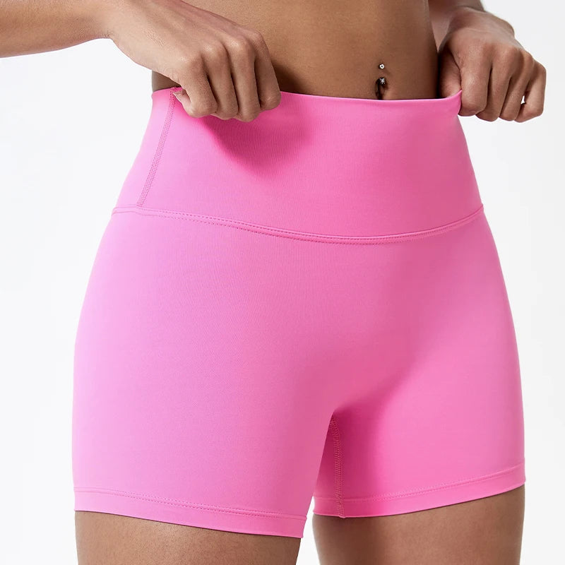 Gros plan d'une femme portant des shorts de yoga et de sport roses vifs à taille haute.