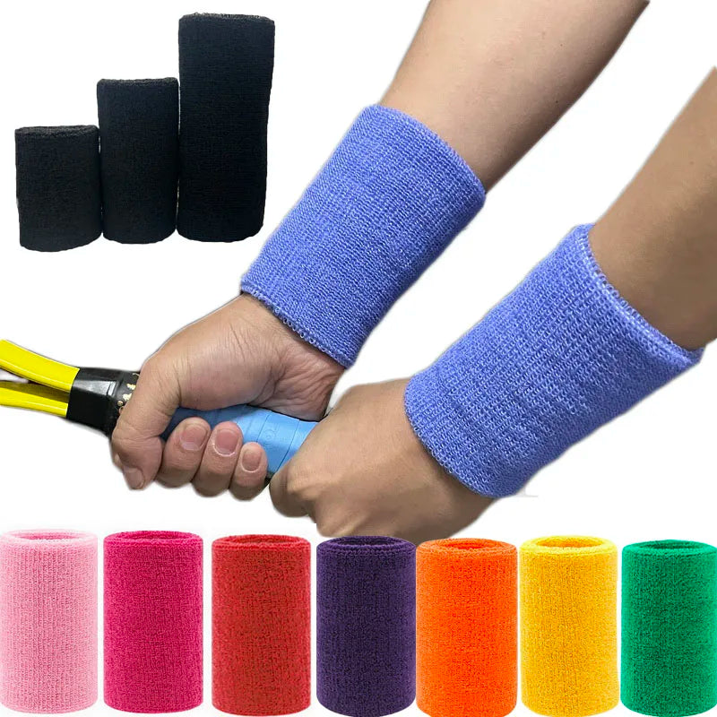 A hand is wearing a purple wristband, with various colored wristbands displayed nearby.