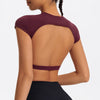 A woman wearing a maroon women's fitness crop top yoga and gym t-shirt from the back.