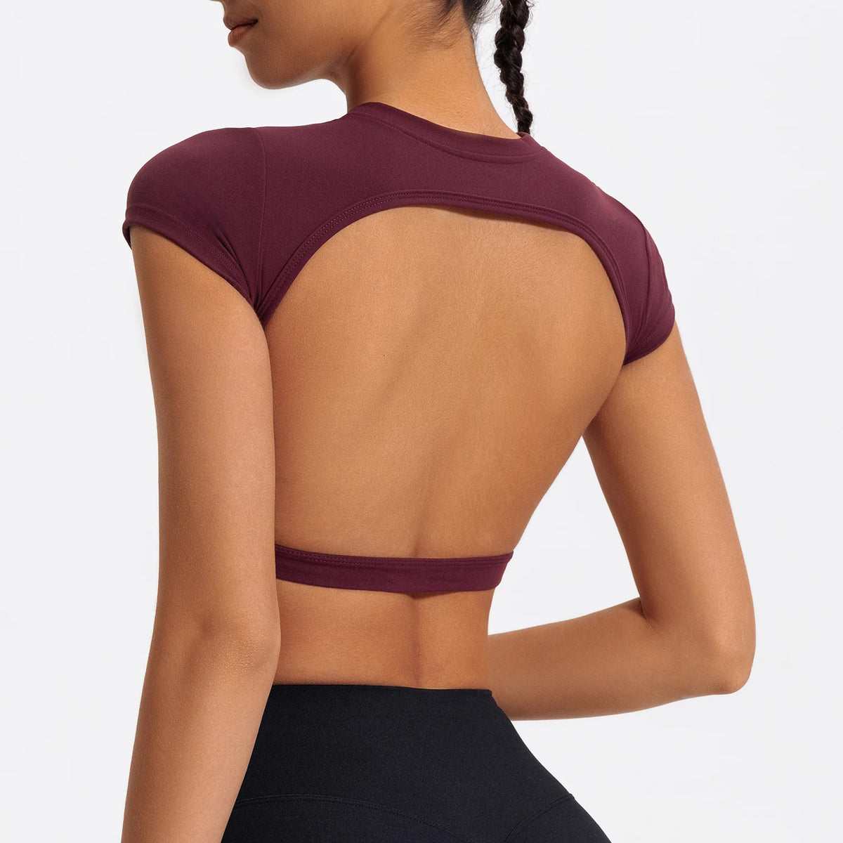 A woman wearing a maroon women's fitness crop top yoga and gym t-shirt from the back.