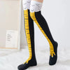 Chaussettes noires montantes avec des rayures de poulet en dessin jaune et un ourlet blanc